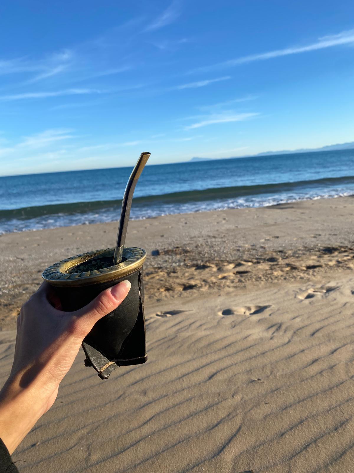 Berenice tomando mate en la playa